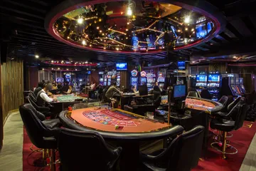 Um close de moedas douradas caindo ao redor de uma roleta girando, representando a ação imersiva do cassino no FIXE777.